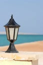 Black lantern along seashore