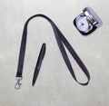 Black Lanyard Neck Strap with Metal Lobster Clip and black pen, silver table office clock. On grey table