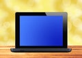 Black laptop on wooden table over blurred background Royalty Free Stock Photo