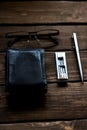 black lather wallet whit pen  eyeglasses and steel multitool on wooden table Royalty Free Stock Photo