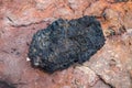 Black lava rock from volcano on a pumice background. Royalty Free Stock Photo