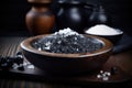Black lava salt is a salt with a distinctive glossy black color, coarse grain in a wooden bowl