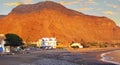 Black lava sand beach, small town at foot of red mighty rock face, sunset sky - La Puntilla, Valle Gran Rey, La Gomera