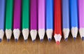 Black lead pencils lie in a row, one pencil has a red core and put forward , small depth of sharpness Royalty Free Stock Photo