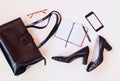 Black leather bag, shoes, notepad, smartphone and glasses. Royalty Free Stock Photo