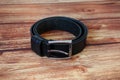 Black leather belt on wooden background Royalty Free Stock Photo