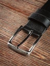 Black leather belt on a wooden brown background Royalty Free Stock Photo