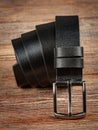 Black leather belt on a wooden brown background Royalty Free Stock Photo