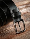 Black leather belt on a wooden brown background Royalty Free Stock Photo