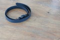 Black leather belt on wooden table Royalty Free Stock Photo