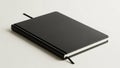 Black leather-bound notebook on a light cream background Royalty Free Stock Photo