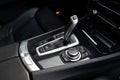 Black leather car interior with modern gear shift lever and control buttons for multimedia dashboard. Deluxe vehicle Royalty Free Stock Photo