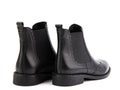 Black leather chelsea boots with black elasticated side details, pattern details and black rubber sole. Isolated close