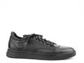 Black leather classic sneakers with laces. Casual men's style. Black rubber soles. Isolated close-up on white Royalty Free Stock Photo