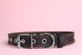 Black leather dog collar on pink background, closeup. Space for text Royalty Free Stock Photo