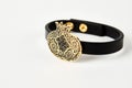 Black leather and gold cuff bracelet on white background with copy space