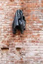 Black leather jacket on the background of an old red brick wall of an abandoned building Royalty Free Stock Photo