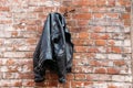 Black leather jacket on the background of an old red brick wall of an abandoned building Royalty Free Stock Photo