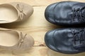 Black leather man shoes opposite an elegant beige woman shoes Royalty Free Stock Photo