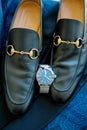 Black leather men shoes stand on a blue suit next to a wristwatch Royalty Free Stock Photo