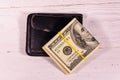 Black leather money clip with the one hundred dollar bills on wooden table. Top view Royalty Free Stock Photo