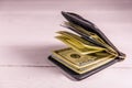 Black leather money clip with the one hundred dollar bills on wooden table Royalty Free Stock Photo