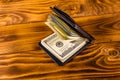 Black leather money clip with the one hundred dollar bills on wooden table Royalty Free Stock Photo