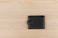 Black leather purse lying on a wooden table. Royalty Free Stock Photo