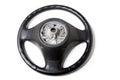 Black leather shiny steering wheel with a metal frame a separate part of the car on a white isolated background in the workshop Royalty Free Stock Photo