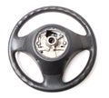 Black leather shiny steering wheel with a metal frame a separate part of the car on a white isolated background in the workshop Royalty Free Stock Photo