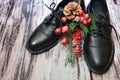 Black leather shoes and Christmas decor on wooden background. Pair of stylish women`s boots and spruce twig with Christmas toys Royalty Free Stock Photo