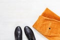 Black leather shoes and orange corduroy Womens pants on white wooden surface with copy space. Female clothes Royalty Free Stock Photo