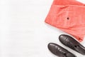 Black leather shoes and pink corduroy Womens pants on white wooden surface