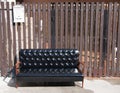 Black leather sofa and wooden armrest chair with white mailbox on brown background. Royalty Free Stock Photo