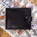 Black leather wallet above to banknotes and coins US. Closed. Finance background. Concept of saving money in a crisis and home Royalty Free Stock Photo