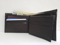 black leather wallet with american dollars banknotes and white background