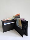 black leather wallet with australian banknotes and white background
