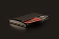 Black leather wallet with credit and discount cards on black background Royalty Free Stock Photo