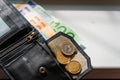 Black leather wallet with money euro inside it.Black wallet with euro money lying on the windowsill.Selective focus Royalty Free Stock Photo