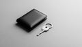 Black leather wallet and silver metal key on a smooth, light gray surface. The wallet is folded and Royalty Free Stock Photo