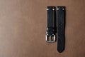 Black leather watch strap with stainless buckle on leather background, Craft and handmade watch bracelet.