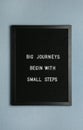 Black letter board with motivational quote Big Journey Begin with Small Steps on color background, top view Royalty Free Stock Photo