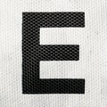 Black letter E on white painted fabric material. English alphabet.