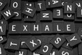 Black letter tiles spelling the word & x22;exhale& x22;