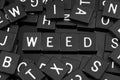 Black letter tiles spelling the word & x22;weed& x22; Royalty Free Stock Photo