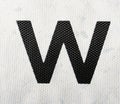 Black letter W on white painted fabric material. English alphabet.
