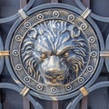 Iron gilded lion on a forged gate. Closeup. Black lion head with golden patina. Decorative forging. Iron forged head of