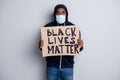 Black lives matter concept. Photo of serious dark skin african poor cold protester placard community against black