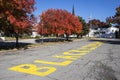 Black Lives Matter painted on church parking lot with beautiful autumn trees and American flag and steeple Royalty Free Stock Photo