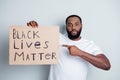 Black lives matter. Photo of disappointed dark skin african protester direct finger placard demonstrate society attitude